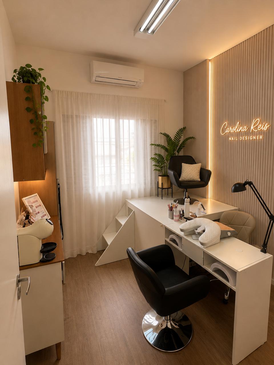 Sala de nail designer do Espaço Elegance, com letreiro neon Carolina Reis, mesa de manicure e poltrona