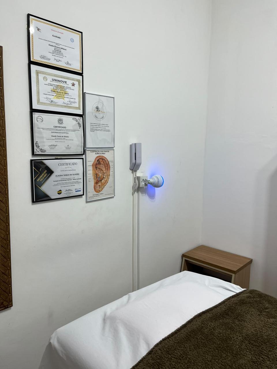 Certificados de estética e enfermagem de Claudia Oliveira na parede da sala de atendimento