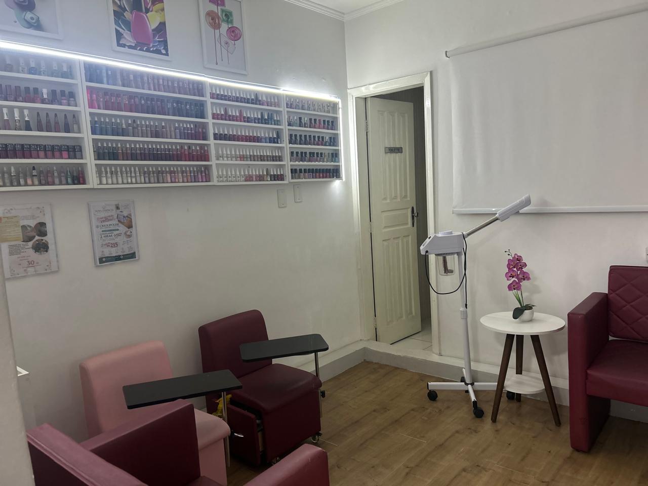 Sala de manicure e pedicure do Espaço Elegance, com poltronas e expositor de esmaltes